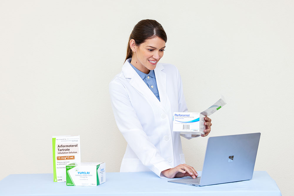 Pharmacy White Female Pharmacist Smiling Laptop Unit Dose Medications Arformoterol Tartrate Yupelri Perforomist