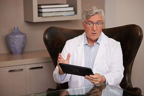 Telehealth WhiteMaleDoctorwithGlasses TalkingonTablet